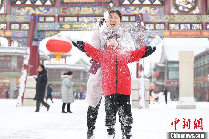 2月13日，家長與小朋友在呼和浩特市大召廣場享雪趣?！⑽娜A 攝