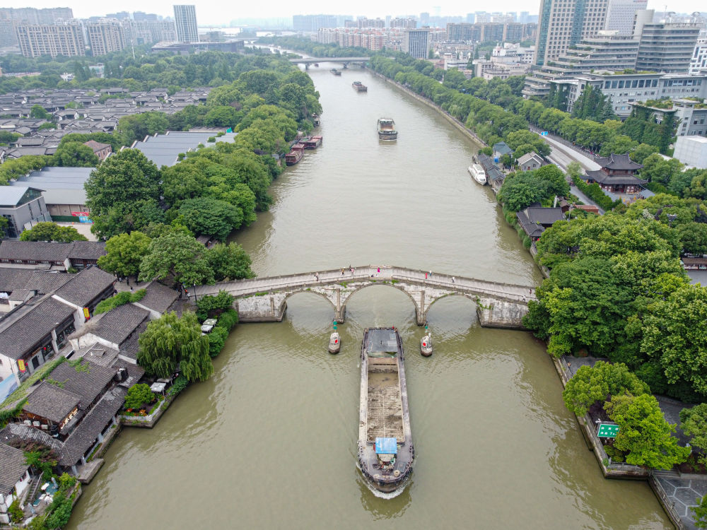 5月27日，一艘貨船駛過京杭大運河南端標(biāo)志建筑杭州拱宸橋。(無人機照片)新華社記者江漢 攝