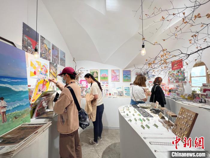 圖為藝術(shù)品商店內(nèi)，顧客挑選插畫(huà)作品?！＄婌?攝