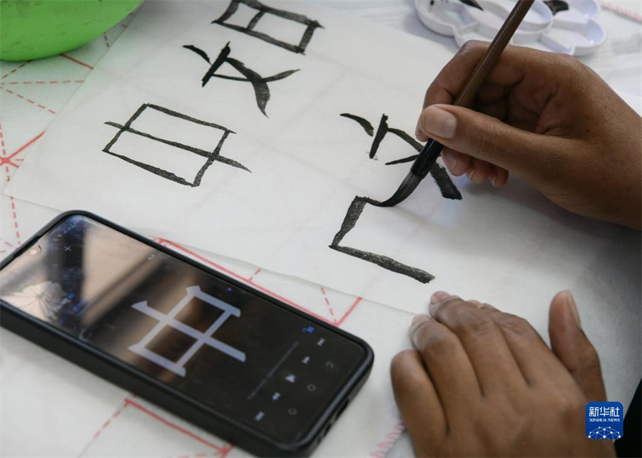 4月18日，肯尼亞學(xué)生在內(nèi)羅畢大學(xué)孔子學(xué)院舉辦的活動(dòng)上寫毛筆字。肯尼亞內(nèi)羅畢大學(xué)孔子學(xué)院18日舉辦“中文，增進(jìn)文明對話”主題活動(dòng)，慶祝即將到來的第14個(gè)聯(lián)合國中文日?？夏醽唽W(xué)生參與互動(dòng)，進(jìn)行書法、剪紙、唱中文歌等活動(dòng)。新華社記者 韓旭 攝