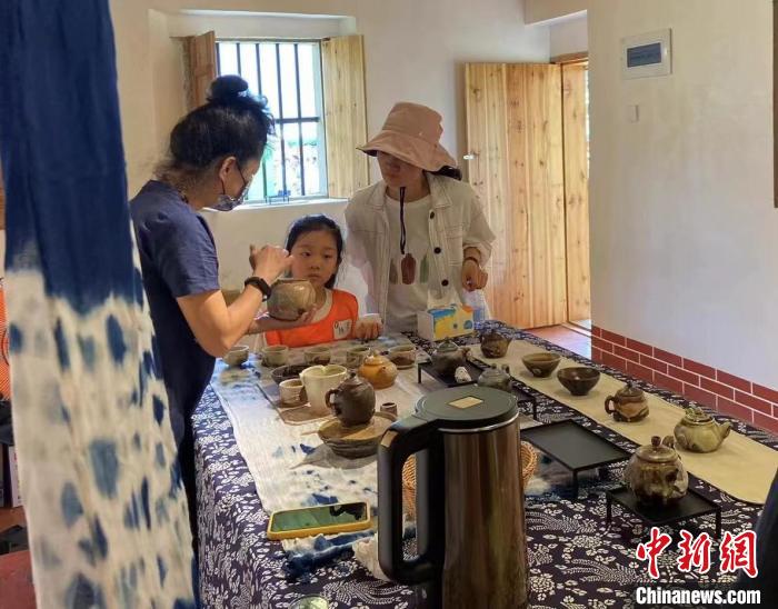 圖為：游客正在咨詢臺(tái)灣柴燒作品?！∪~秋云 攝