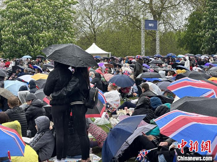 當(dāng)?shù)貢r間5月6日，英國國王查爾斯三世的加冕儀式舉行。民眾雨中觀看儀式。　歐陽開宇 攝
