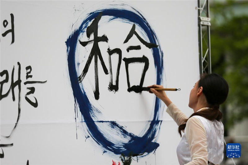 5月30日，在韓國首爾舉辦的“中日韓合作之日”慶?；顒又校硌菡哌M行中日韓精神——2023年度漢字“和合”書法表演。新華社記者 王益亮 攝