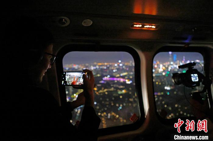 6月3日晚，游客乘坐上海新空直升機(jī)有限公司直升機(jī)開啟鳥瞰黃浦江空中圓夢之旅，并用手機(jī)拍攝城市夜景。　殷立勤 攝