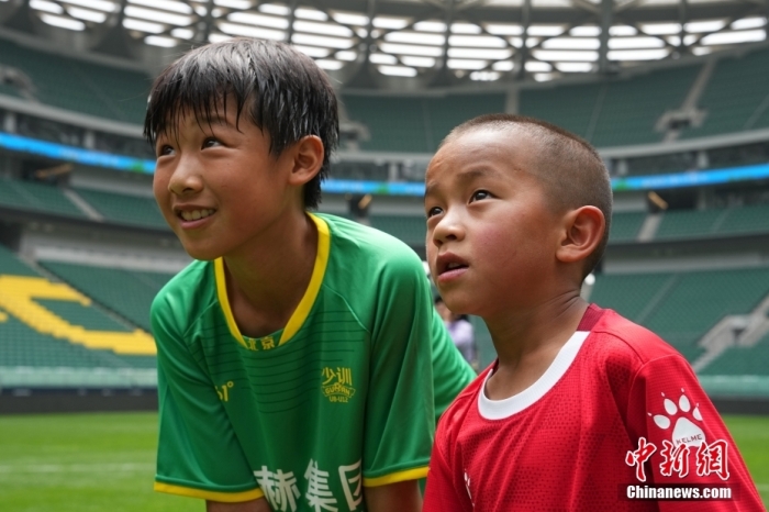 圖為北京國安小球員陳小北和7歲的俄金仁增在一起觀看場內(nèi)播放的紀(jì)錄片。<a target='_blank' href='/' _fcksavedurl='/'><p  align=
