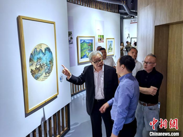 海峽兩岸藝術(shù)家畫展上，藝術(shù)家進行藝術(shù)交流?！「毒窜?攝