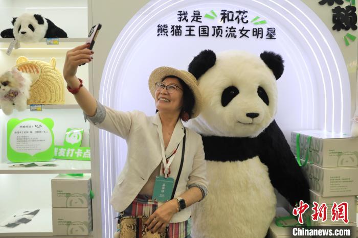 美國華視總裁楊蓮花與大熊貓文創(chuàng)產(chǎn)品合影?！⊥趵?攝
