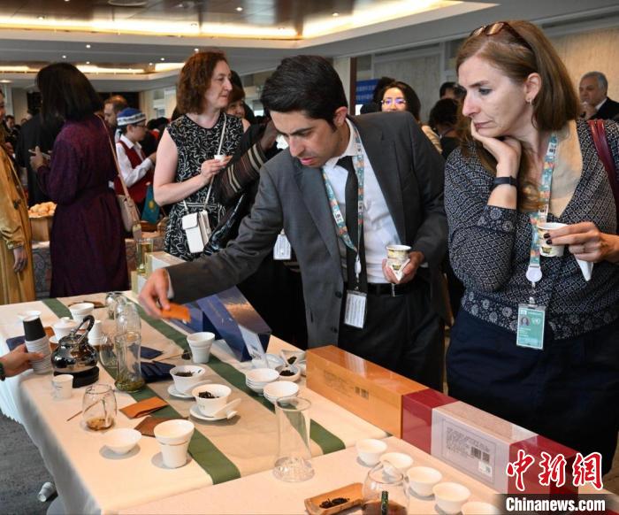 現(xiàn)場(chǎng)觀眾觀看中國(guó)展臺(tái)茶藝表演、了解茶文化。　靖樹 攝