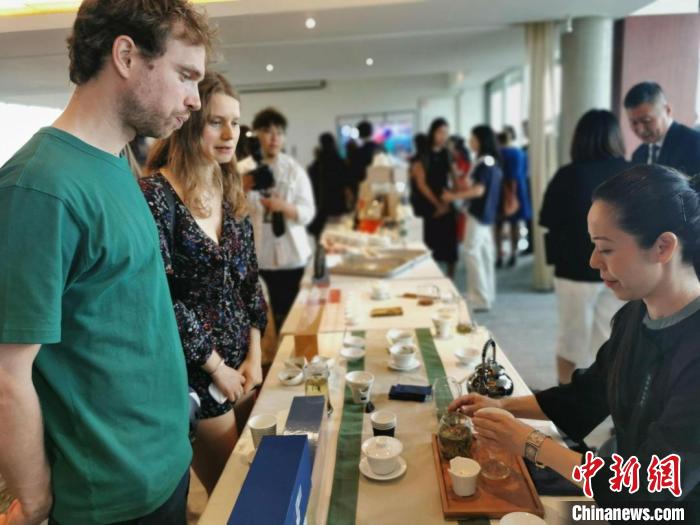 現(xiàn)場(chǎng)觀眾觀看中國(guó)展臺(tái)茶藝表演、了解茶文化?！【笜?攝