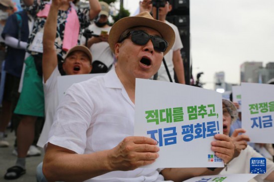 7月22日，在韓國首爾，人們手舉標語參與反戰(zhàn)游行。新華社發(fā)（楊暢 攝）