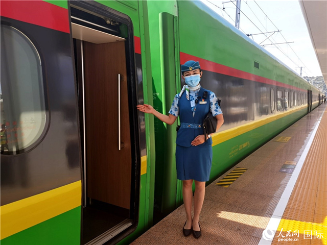 趙瑩靜站在“復興號”國際旅客列車車廂門口歡迎旅客上車。人民網(wǎng) 杜明明攝