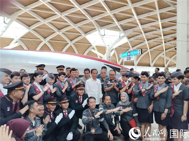 印尼總統(tǒng)佐科與雅萬高鐵乘務(wù)員及中印尼嘉賓合影。人民網(wǎng)記者 李培松攝