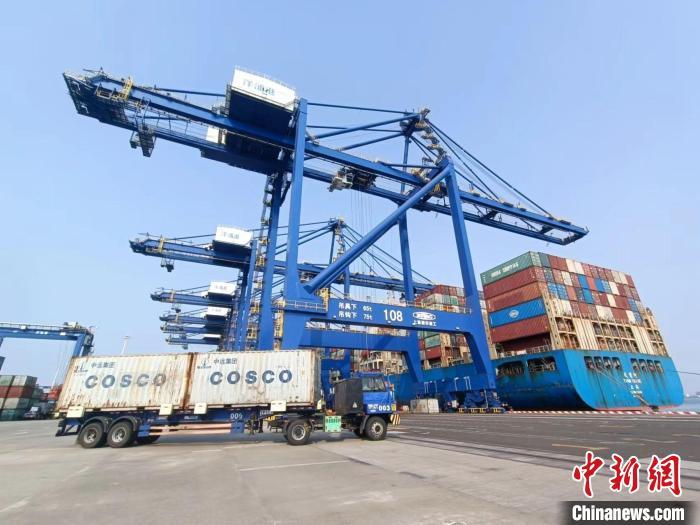 圖為海南洋浦國際集裝箱碼頭，卡車將集裝箱從后方堆場運(yùn)往碼頭裝卸區(qū)?！?jiān)潞?攝