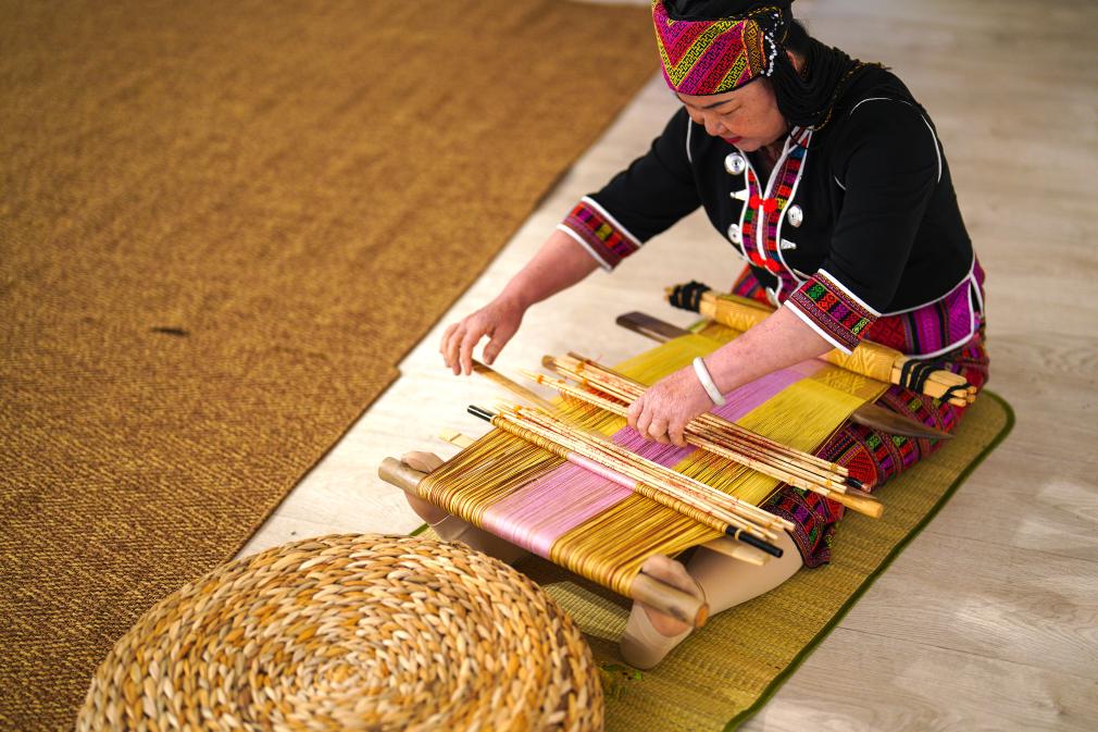 4月17日，黎族傳統(tǒng)紡染織繡技藝國家級代表性傳承人劉香蘭在2023年意大利米蘭設(shè)計周上展示黎錦織造技藝。新華社發(fā)