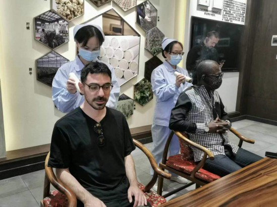 2023“一帶一路”媒體合作論壇聯(lián)合采訪團(tuán)團(tuán)員在九牛草展示館體驗(yàn)艾灸。（本報(bào)記者 黃超攝）