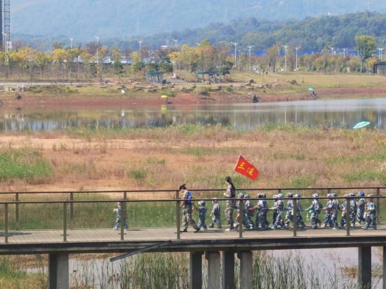 　　10月24日，秋游的幼兒園小朋友在老師帶領(lǐng)下走在清水塘公園里的木橋上。本報(bào)記者 常雯宜攝
