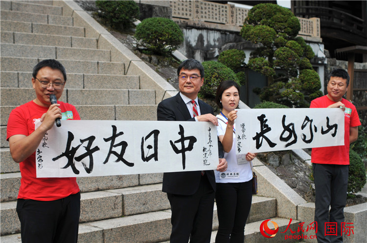 東京中國文化中心主任羅玉泉展示其為本次活動書寫的題詞“中日友好，山高水長”。人民網(wǎng) 蔣曉辰攝
