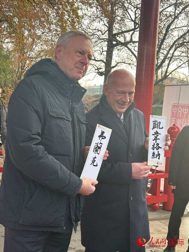 柏林市長(zhǎng)韋格納（右）、動(dòng)物園監(jiān)事會(huì)主席布魯克曼（左）手持中國(guó)文化中心工作人員現(xiàn)場(chǎng)手書(shū)的中文名字。人民網(wǎng)記者 徐馨攝