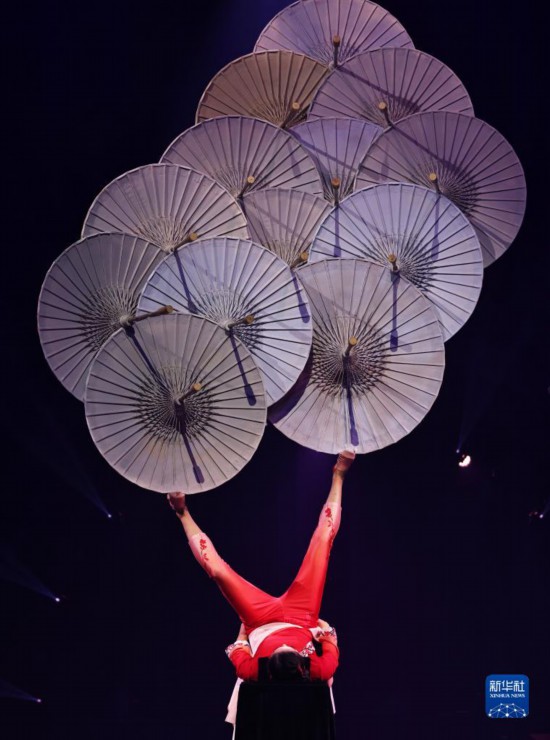 12月8日，演員在法國(guó)巴黎舉行的中國(guó)雜技“奇妙之夜”演出上表演《蹬傘》。新華社記者 高靜 攝