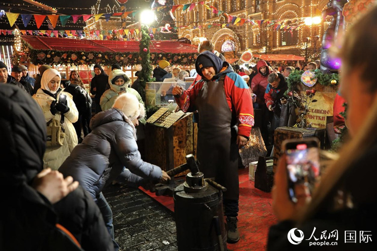 游客在新年集市上體驗(yàn)制作紀(jì)念幣。人民網(wǎng)記者 隋鑫攝