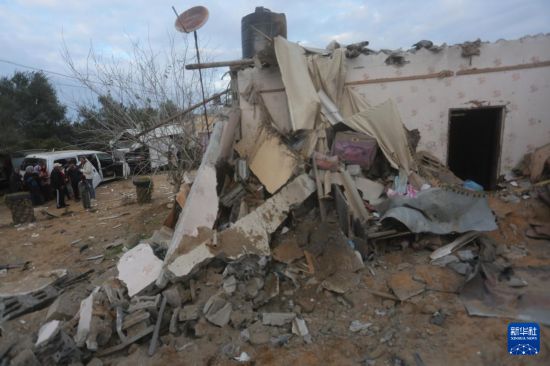 2月5日，在加沙地帶南部城市拉法，人們查看以軍空襲后的建筑廢墟。新華社發(fā)（哈立德·奧馬爾攝）