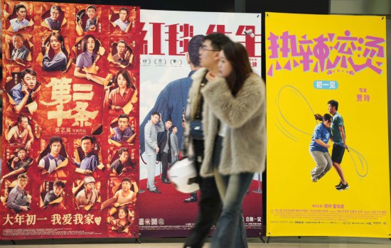 這是2月17日，在沈陽一家影院，觀眾從海報(bào)前經(jīng)過。新華社記者李鋼攝