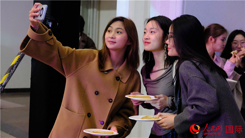 中國觀眾在現場品嘗“謝肉節(jié)”節(jié)日美食——煎薄餅。人民網 褚夢琦攝