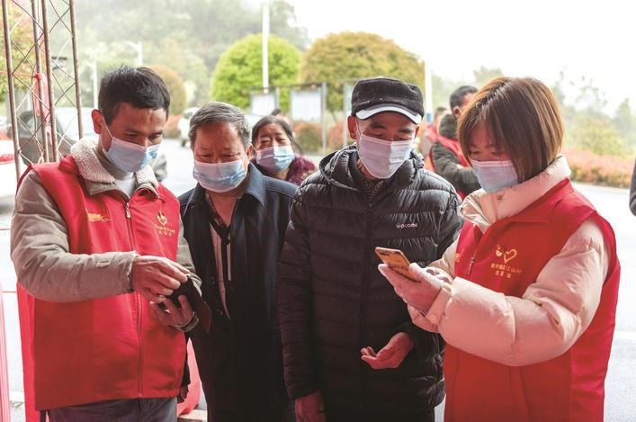 長沙縣黨員志愿者正在幫助參與核酸檢測的群眾掃描“場所碼”。劉思源 攝