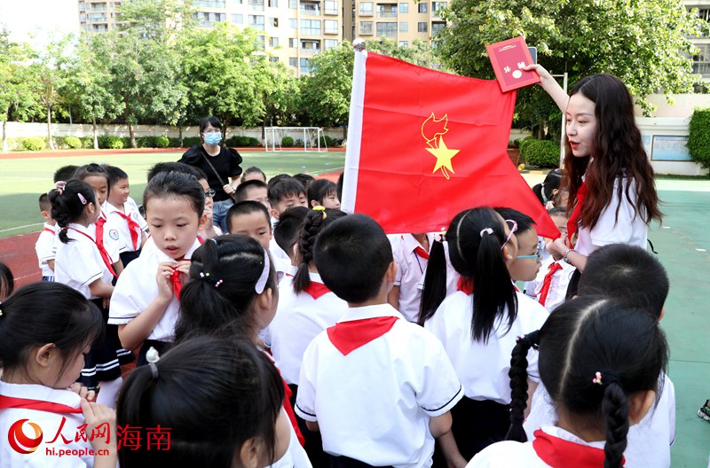 老師向少先隊員展示隊旗。人民網(wǎng) 符武平攝
