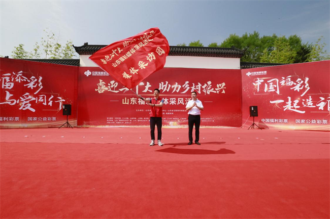為媒體采風(fēng)團授旗。 山東省福彩供圖