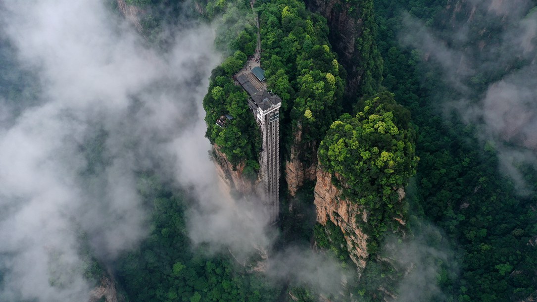 位于張家界武陵源景區(qū)的百龍?zhí)焯蓁偳对谠旗F繚繞的峰林間，雄偉壯觀。吳勇兵攝