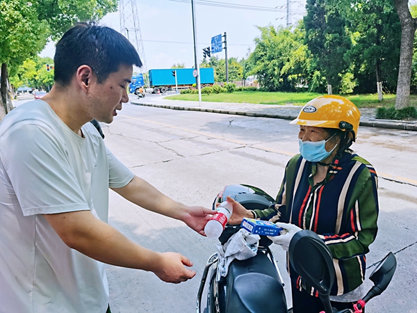 何超為過路的老人送上礦泉水和冷飲。人民網(wǎng)記者 王繼亮攝