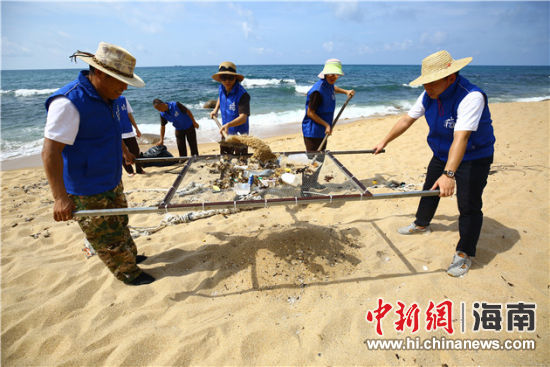 環(huán)保志愿者用篩網(wǎng)“淘”出海灘上的垃圾。