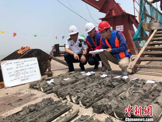 圖為勘察設(shè)計(jì)人員與海事局工作人員查看巖芯情況?！∥赫?攝