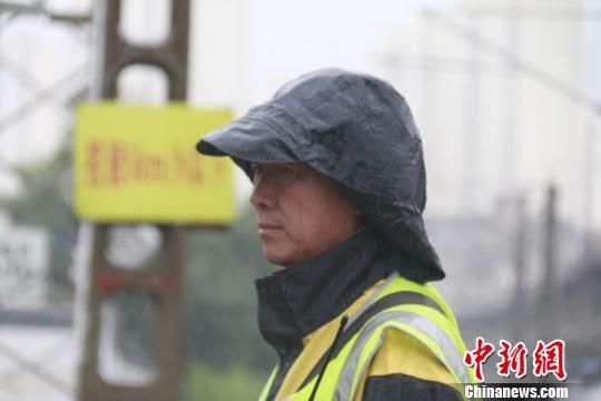 蘭州西工務(wù)段蘭州線路車間防護(hù)員雨中巡查?！⊥豕廨x 攝