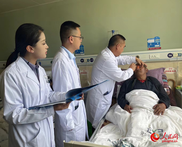 董光明（左三）帶領(lǐng)醫(yī)生對(duì)患者進(jìn)行術(shù)前檢查。人民網(wǎng)記者 杜燕飛攝