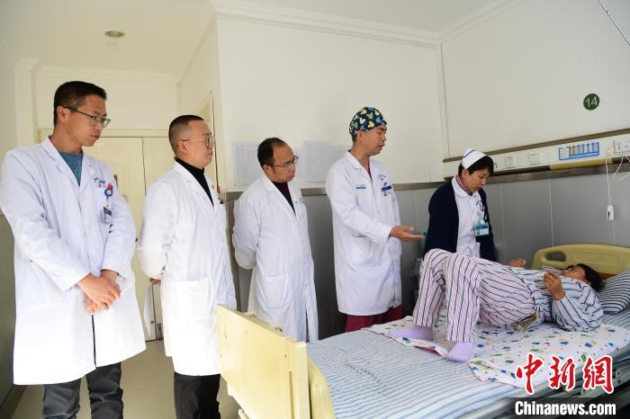 圖為何蔚副主任醫(yī)師(站右二)及團隊術(shù)后指導患者進行腰背肌鍛煉。　貢嘎來松 攝