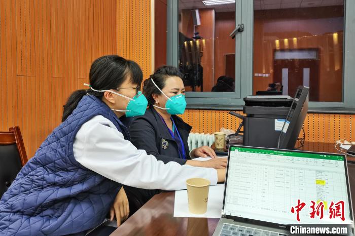8月9日，楊蘇喬(左)在拉薩方艙醫(yī)院指揮部讀取艙內(nèi)患者胸部CT?！∈茉L者供圖