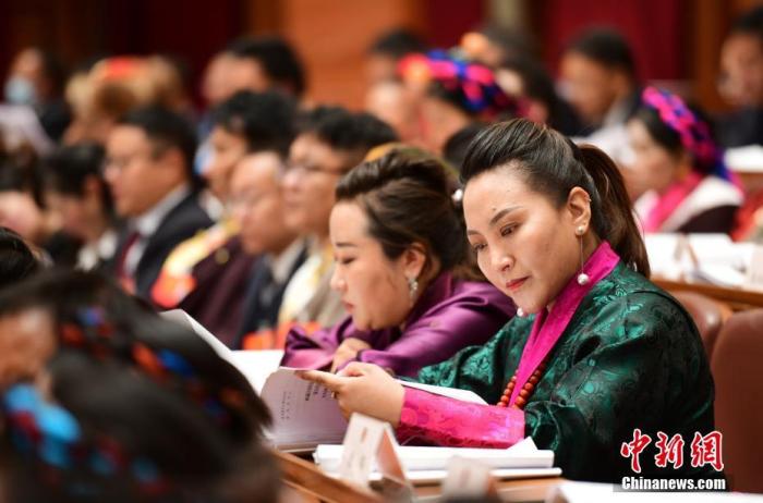 1月5日，次旦卓嘎(右一)在拉薩參加西藏自治區(qū)第十一屆人民代表大會第五次會議第二次全體會議。西藏自治區(qū)人大代表次旦卓嘎來自日喀則市定日縣，定日縣被稱為“洛諧故鄉(xiāng)”，作為西藏民間歌舞，洛諧已被列入中國國家非物質(zhì)文化遺產(chǎn)項(xiàng)目名錄，這是集歌、舞、樂、彈唱于一體的綜合藝術(shù)形式。參加完西藏2022年新年音樂會的次旦卓嘎告訴記者，每年參加的基層演出可達(dá)80場，“我希望用最純粹的方式，把最好的聲音帶到西藏乃至中國的各個角落?！?<a target='_blank' href='/'><p  align=