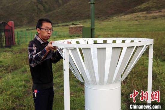 圖為班瑪縣氣象局工作人員在維護(hù)藏雪茶基地氣候站。青海省氣象局供圖