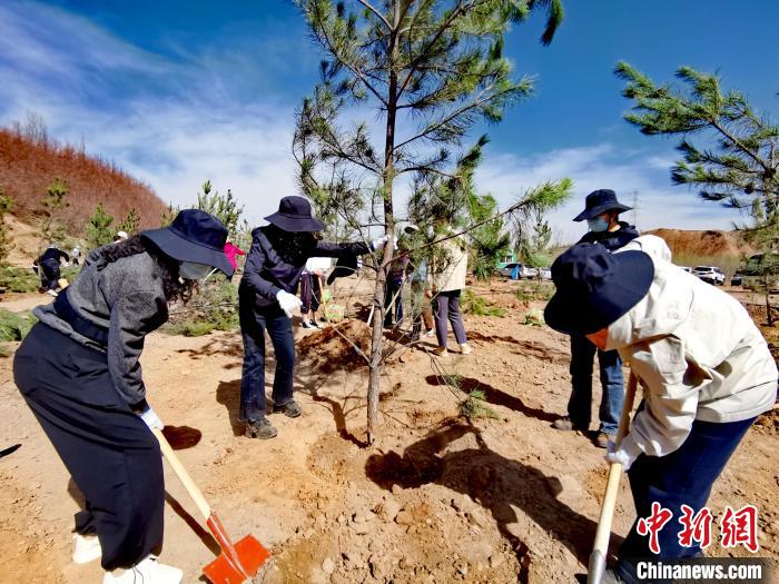 圖為西寧市城東區(qū)干部職工參加義務(wù)植樹?！?zhí)砀?攝
