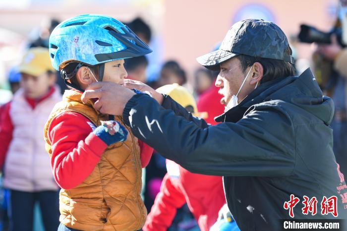 圖為拉薩市實驗幼兒園孩子在教練的幫助下穿戴頭盔?！『闻罾?攝