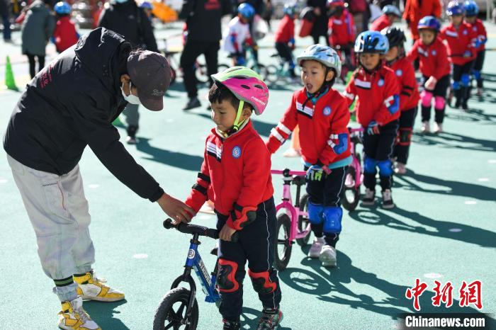 圖為拉薩市實驗幼兒園孩子們在教練的指導(dǎo)下練習滑步車?！『闻罾?攝