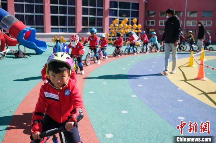 圖為拉薩市實驗幼兒園孩子們在教練的指導(dǎo)下練習滑步車?！『闻罾?攝