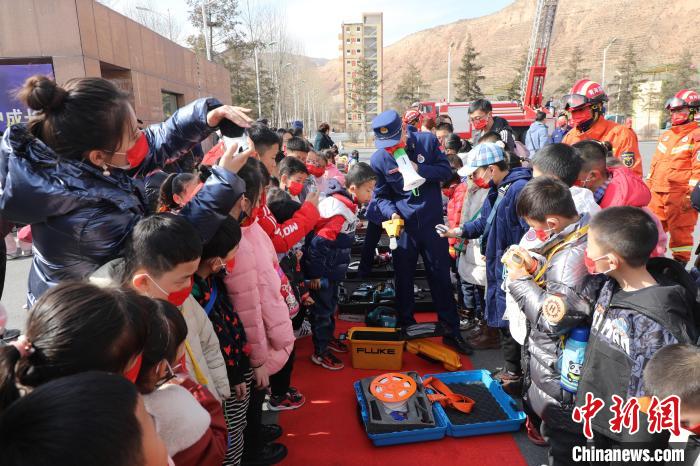 圖為小朋友們聽消防員講解消防器材?！铨埥?攝