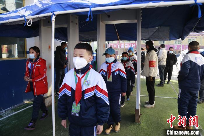圖為學生測量體溫后進入校園?！●R銘言 攝