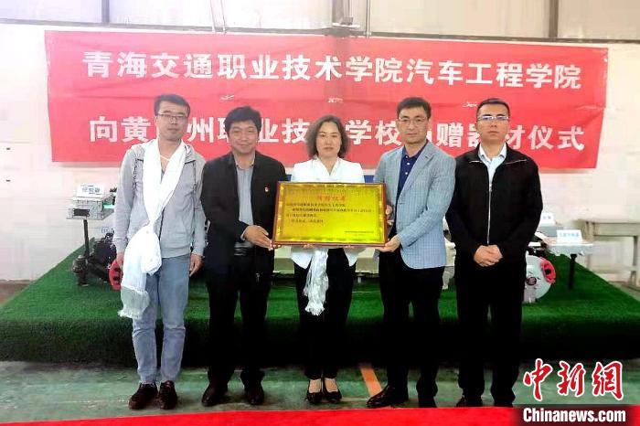 圖為李富香(中)代表學(xué)校為州縣技校捐贈(zèng)器材。(資料圖) 青海省教育廳供圖