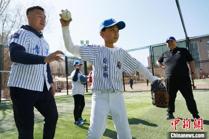 圖為教練指導(dǎo)小棒球手?jǐn)S球技術(shù)?！●R銘言 攝