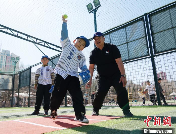 圖為來自臺灣的棒球教練劉興鴻(右)指導(dǎo)小棒球手?jǐn)S球技術(shù)?！●R銘言 攝