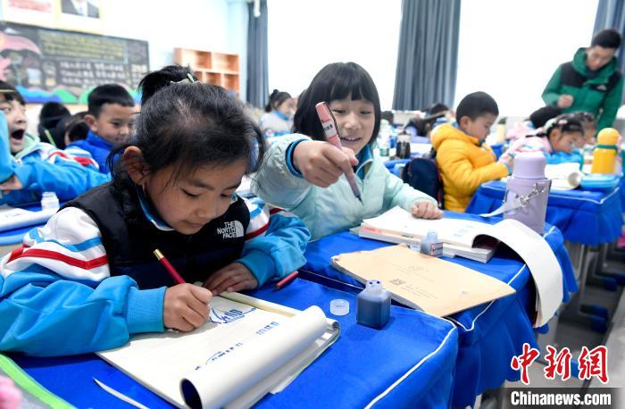 3月14日，西藏拉薩市第一小學(xué)一年級六班學(xué)生白瑪朗珍(圖左)在藏語文課上書寫藏文?！±盍?攝
